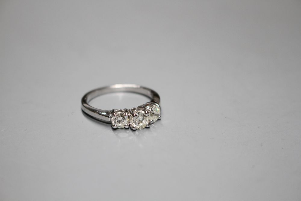 A modern 14k white metal and three stone diamond ring,